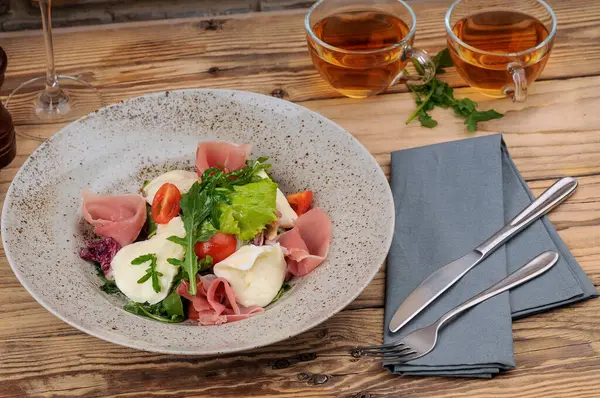 Jambonlu taze domates salatası, mozarella peyniri ve roka.