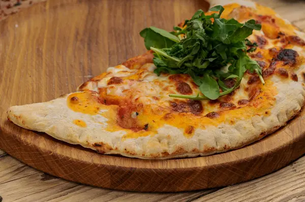 Tahtadaki Calzone pizzasının yakın görüntüsü.