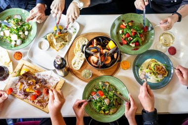 Restoran masasında yemek yiyen arkadaşların en iyi görüntüsü.