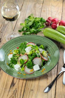 Yeşillik, yumuşak peynir ve ahşap masada dilimlenmiş turplu taze ve lezzetli bir salata.