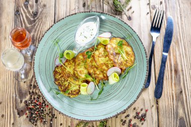 Ahşap masada ekşi kremalı kızarmış kabaklı krep manzarası.