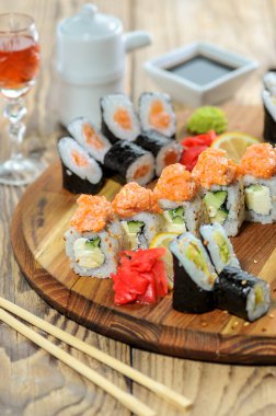 Suşi seti ve yemek çubukları tahtanın üzerinde.