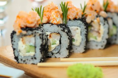 Tahta tahtada havyarlı lezzetli suşi ruloları. Suşi yemeği.