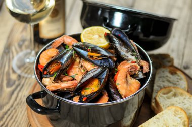 Masadaki siyah soslu midye ve karidesleri kapatın.