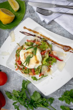 Tabakta kızarmış yumurta ve peynirli taze sebze salatası..