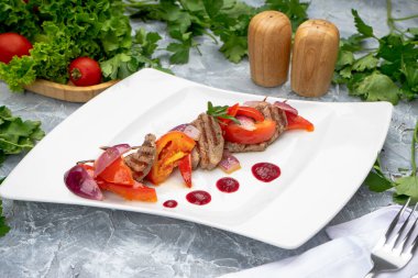 Lezzetli taze et ve beyaz tabakta sebze.