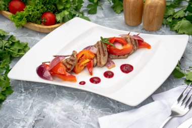 Lezzetli taze et ve beyaz tabakta sebze.