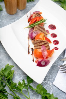 Lezzetli taze et ve beyaz tabakta sebze.