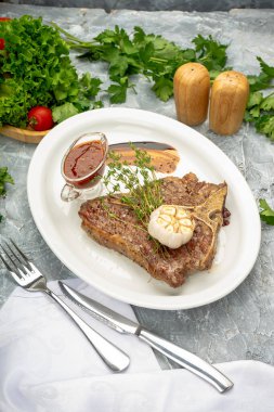 Baharatlı soslu biftek ve tabakta sarımsak..