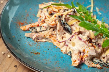 Patlıcanlı salata ve ahşap arka planda mavi tabakta yeşillikli domates.