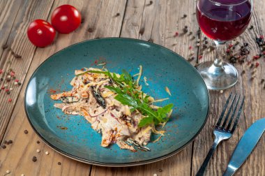 Patlıcanlı salata ve ahşap arka planda mavi tabakta yeşillikli domates.