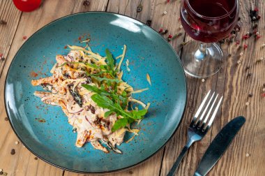 Patlıcanlı salata ve ahşap arka planda mavi tabakta yeşillikli domates.