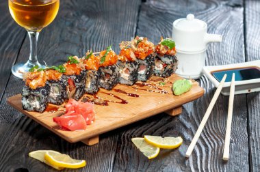 Ahşap bir tahtanın üzerindeki suşi manzarasını kapat.