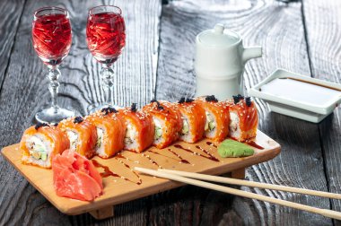 Ahşap bir tahtanın üzerindeki suşi manzarasını kapat.