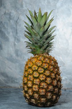 Ananas gri taş arka planda duruyor.