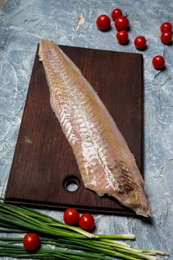 raw fish fillet with spices on the old wooden cutting board. clipart