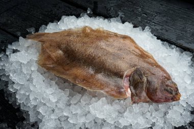 Ezilmiş buzun üzerindeki çiğ balık ahşap yüzeyde uzanıyordu.