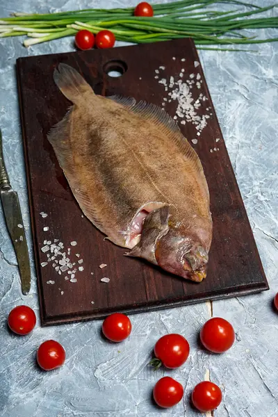 Eski ahşap kesme tahtasına baharatlı çiğ balık.