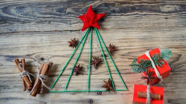 Noel arkaplanı köknar ağacı, Noel süslemeleri, hediye kutuları ve ahşap arka plandaki baharatlar.