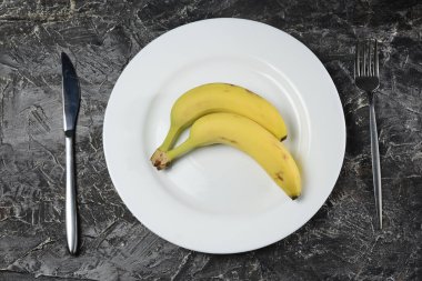 Beyaz tabakta taze muzlar, masada çatal ve bıçak