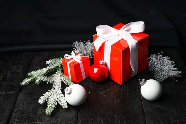 Karanlık arka planda süslemeleri olan Noel hediyeleri.