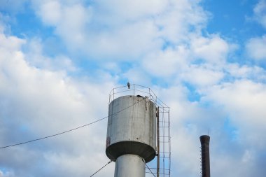 Metal su kulesi ve gökyüzü arka planında boru