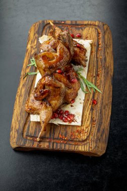 Baharatlı ve otlu kızarmış tavuk budu. Tahta kesme tahtasının üzerinde. Tahta bir masada..