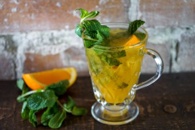Bir fincan portakal ve nane yapraklı çay.