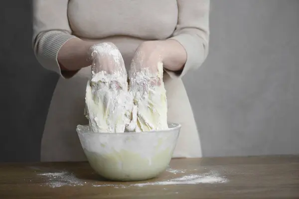 Kadın mutfakta pişirmek için lezzetli hamur hazırlıyor.