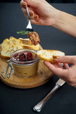 Ahşap masada ekmek ve çatal servis eden kadın.