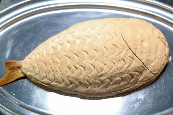 Metal tepside hamur içinde pişmiş balık.