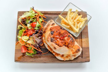 Lezzetli kapalı pizza, salata ve patates kızartması.