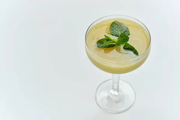 Beyaz arka planda buzlu lezzetli bir kokteyl, yakın plan. 