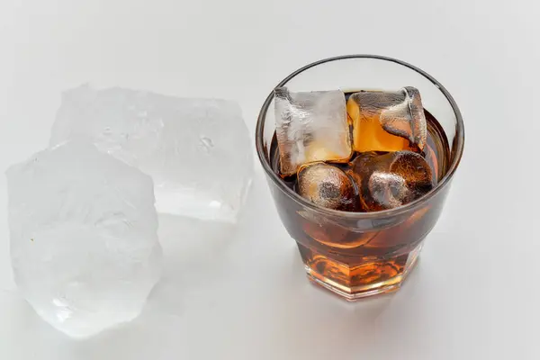 Beyaz arka planda buzlu lezzetli bir kokteyl, yakın plan. 