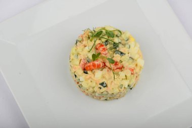 Beyaz tabakta servis edilen karidesli Olivier salatası.