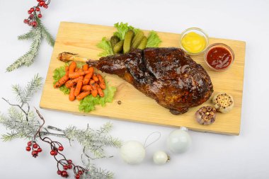 Kızarmış ördek budu, salata ve sebze turşusu. Masada dallar, toplar ve böğürtlenlerle servis ediliyor. 