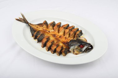 Kızarmış balık, beyaz tabakta servis edilir.