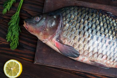 Tahtaya limon ve dereotlu sazan balığı konmuş.