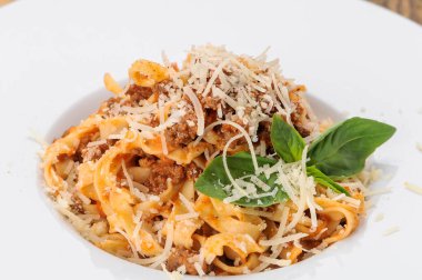 Tagliatelle bolonez üzerine parmesan peyniri ve taze fesleğen..