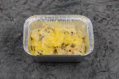 Kremalı sosta pişmiş tavuk ve mantarla servis edilen, folyo kabında servis edilen bir servis tabağı..