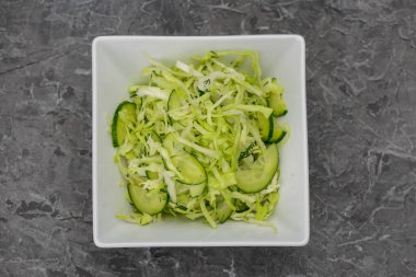 İnce dilimlenmiş salatalık ve doğranmış lahana..