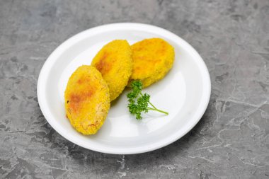 Beyaz tabakta üç kızarmış kabak keki..