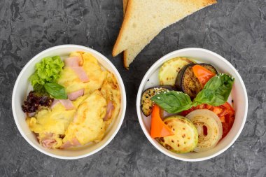 İki konteynır içinde omlet, ızgara sebze ve tost var..