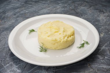 Beyaz tabakta dereotlu patates püresi..