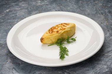 Beyaz tabakta otlu et köftesi..