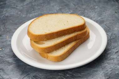 Beyaz bir tabakta üç dilim beyaz ekmek.