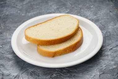 Beyaz bir tabakta iki dilim beyaz ekmek.