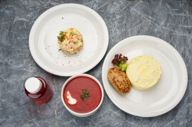 Patates püresi, çorba, balık pirzolası ve içecek..