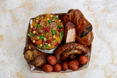 İçinde fırında et, yumurta ve kek de dahil olmak üzere çeşitli geleneksel Paskalya yemekleri bulunan bir kutu..