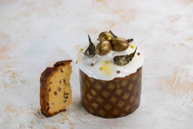 Beyaz kremalı Paskalya pastası ve altın çikolatalı yumurta ve yapraklarla süslenmiş.